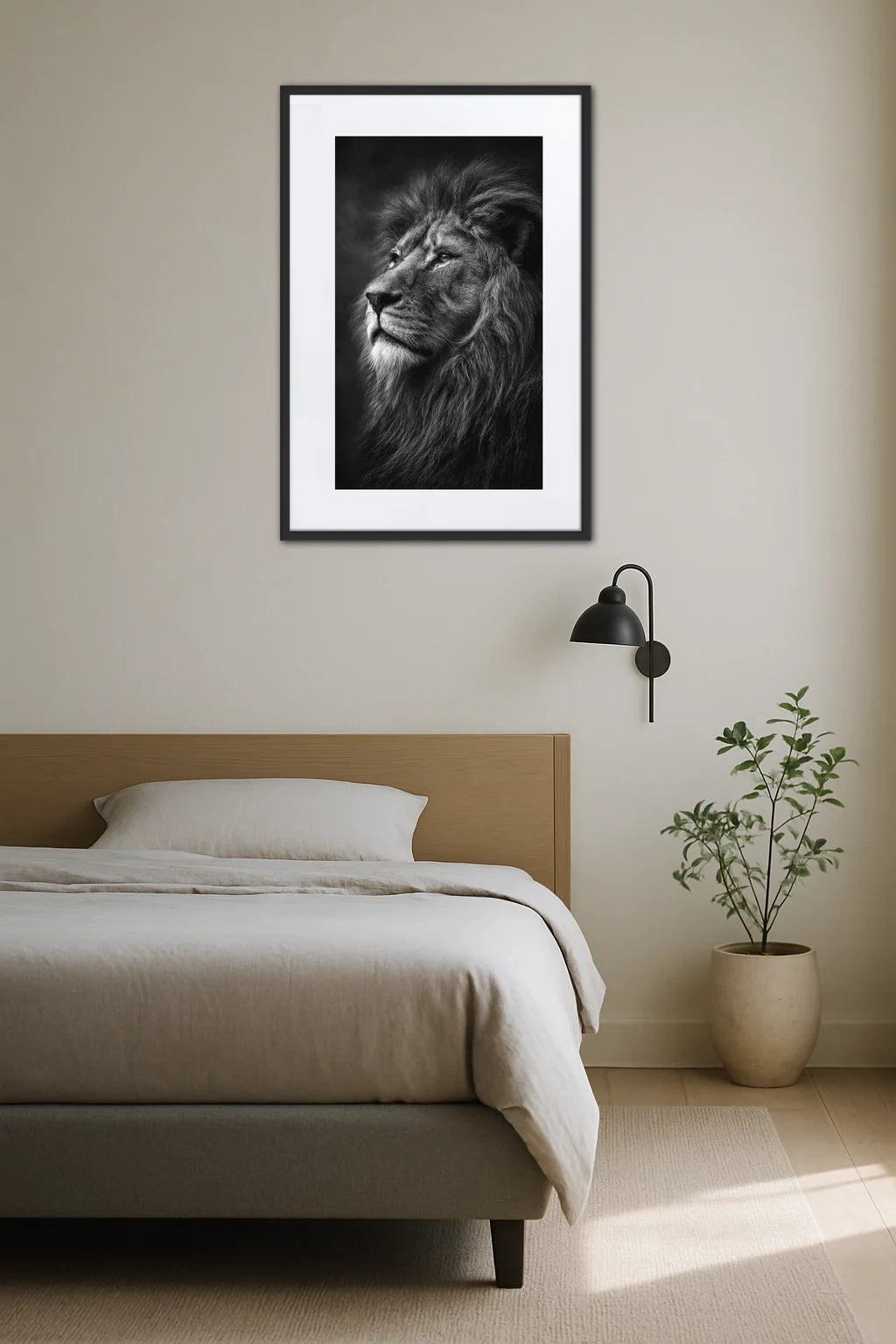 Tableau lion noir et blanc clair obscur au-dessus d’un lit dans une chambre minimaliste