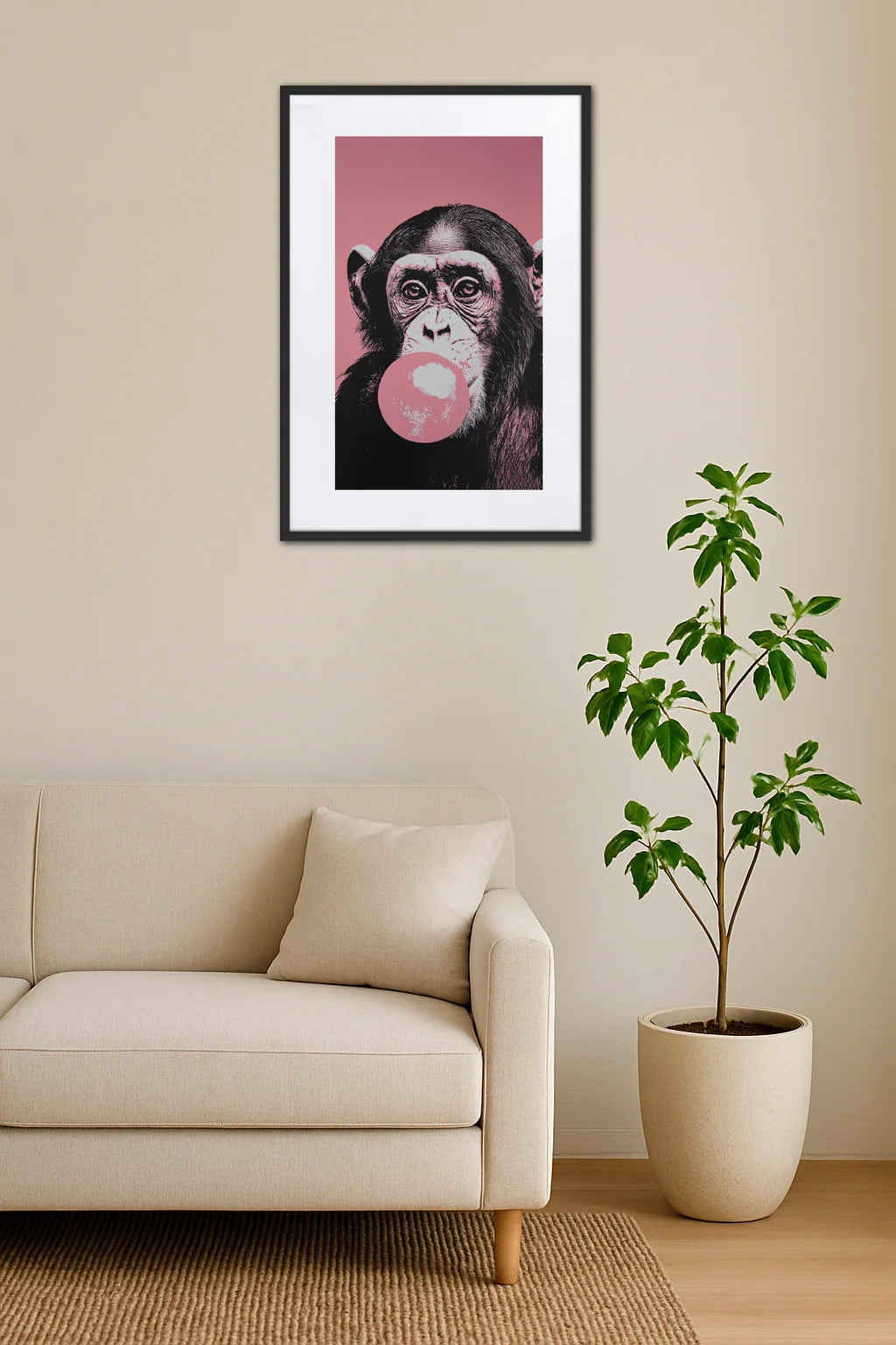 tableau singe bubble gum rose au dessus d’un canapé avec plante