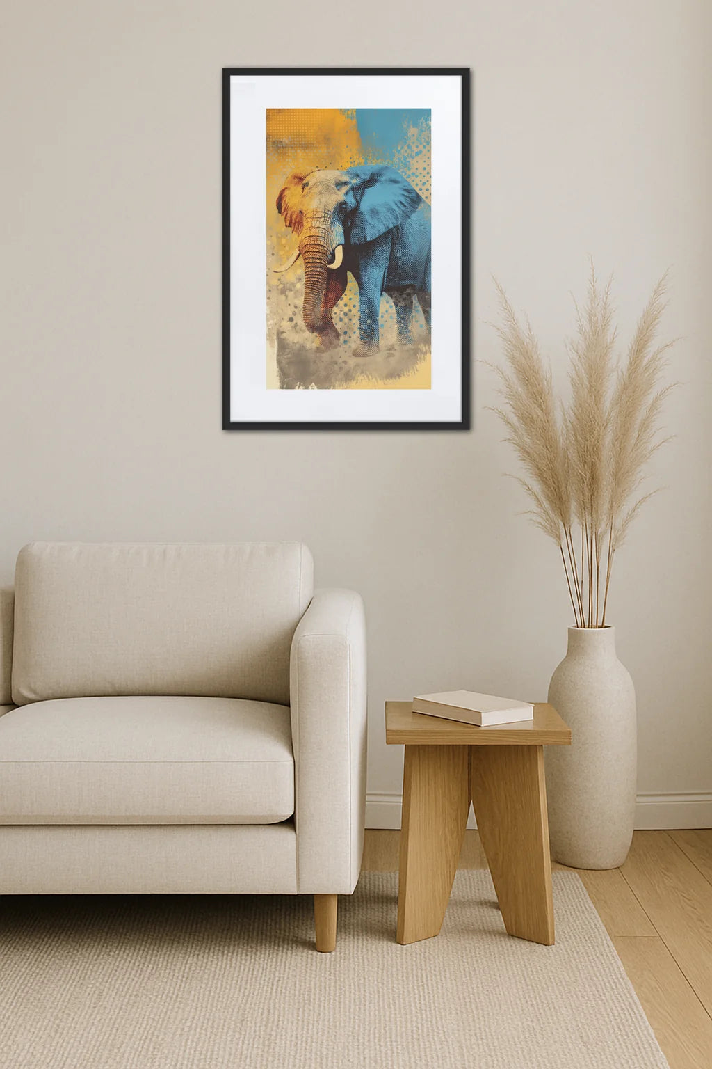 Toile éléphant pop art vintage accrochée au-dessus d’un fauteuil beige avec table en bois, livre et vase avec herbes séchées dans un intérieur clair