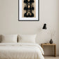 Tableau 3 singes capitalisme design moderne au-dessus d’un lit avec table de chevet dans une chambre minimaliste