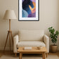 Tableau cheval abstrait en aplats de couleurs au-dessus d’un canapé avec table basse en bois et lampe sur pied