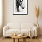 Tableau cheval noir et blanc style fusain au-dessus d’un canapé beige avec table basse en bois dans un salon moderne
