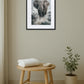 Tableau éléphant gris accroché au mur dans une décoration intérieure avec tabouret et plante
