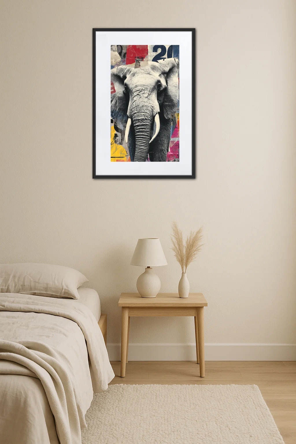 Tableau éléphant noir et blanc de face avec effet collage coloré au-dessus d’une table de chevet avec lampe et vase