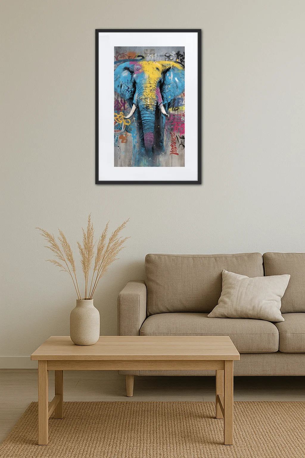 Tableau éléphant pop art street art variation accroché au-dessus d’un canapé beige avec table basse en bois et vase avec herbes séchées