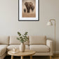 Tableau famille éléphant accroché au mur dans une décoration intérieure avec canapé et table en bois