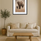 Tableau famille éléphant accroché au mur au-dessus d’un canapé avec table basse
