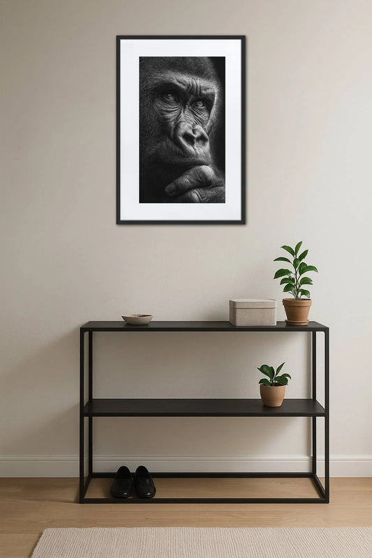 tableau gorille noir et blanc au dessus d’une console noire avec plantes