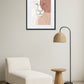 Tableau lion abstrait en traits fins au-dessus d’un fauteuil avec lampe sur pied et petite table en bois