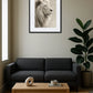 Tableau lion blanc dans un salon avec canapé gris foncé et plante décorative