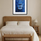 Tableau lion bleu au-dessus d’un lit dans une chambre avec mobilier en bois naturel