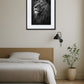 Tableau lion noir et blanc clair obscur au-dessus d’un lit dans une chambre minimaliste