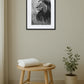 Tableau lion noir et blanc style photo nature dans une salle de bain épurée avec mobilier en bois
