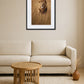 Tableau lion savane dans un salon beige avec canapé et table basse ronde en bois