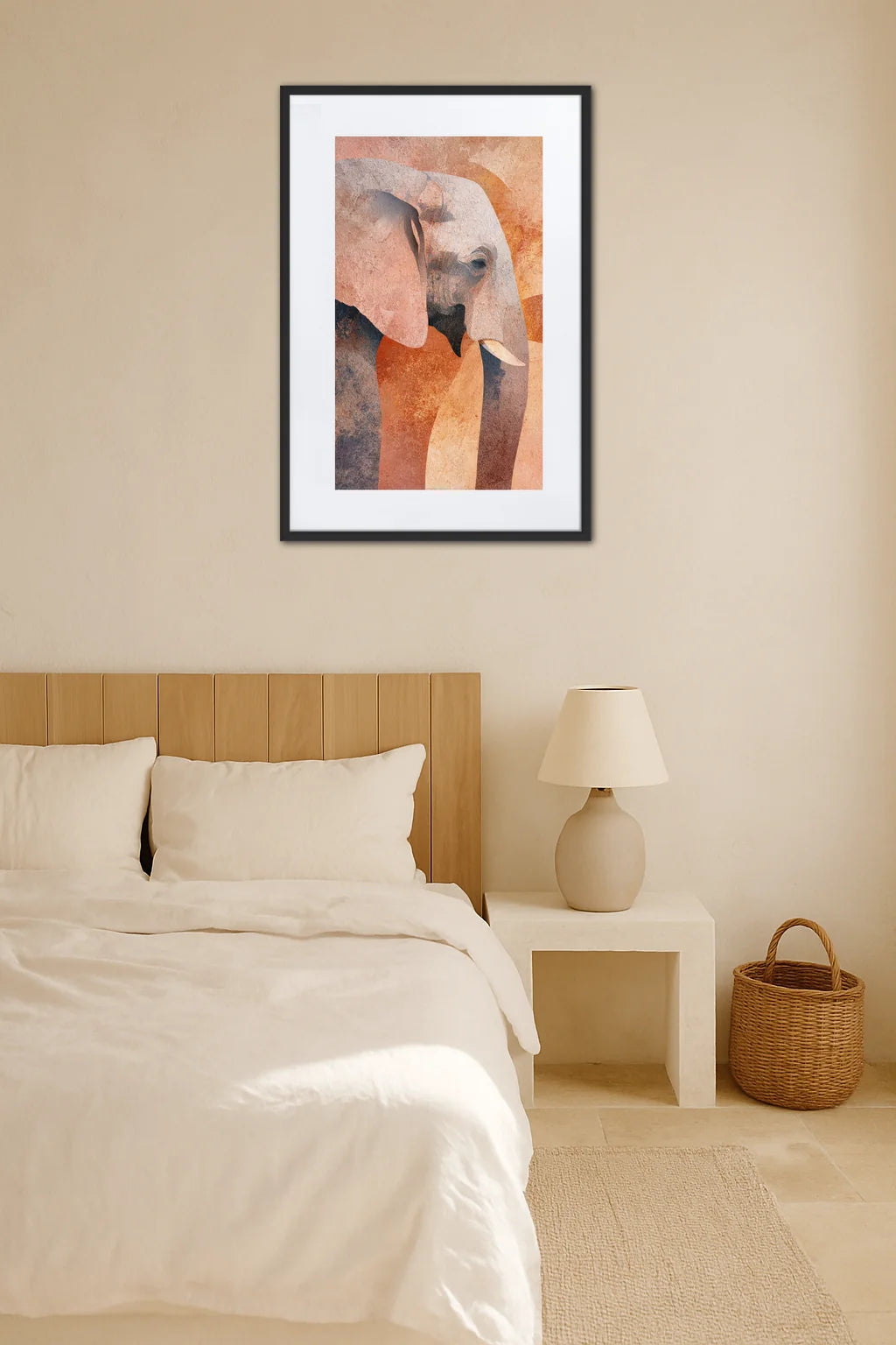 Tableau éléphant abstrait aux tons pastel au-dessus d’un lit dans une chambre beige avec table de chevet et panier en osier