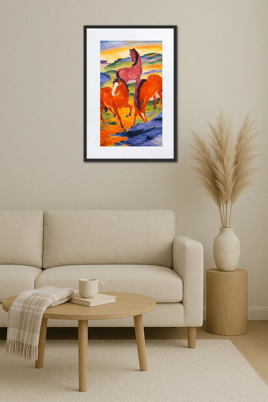 tableau rouge avec chevaux accroché au mur au-dessus d’un canapé beige