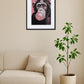 tableau singe bubble gum rose au dessus d’un canapé avec plante