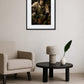 tableau singe jardinier avec chapeau arrosant des plantes au dessus d’un salon avec fauteuil beige et table basse noire