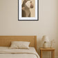 tableau singe moderne minimaliste en profil au dessus d’un lit en bois avec table de chevet et lampe beige