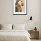 tableau singe moderne style minimaliste en profil au dessus d’un lit avec table de chevet bois, lampe murale noire et décoration épurée