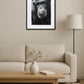 tableau singe noir et blanc style portrait artistique accroché au dessus d’un canapé dans un salon minimaliste avec table basse en bois