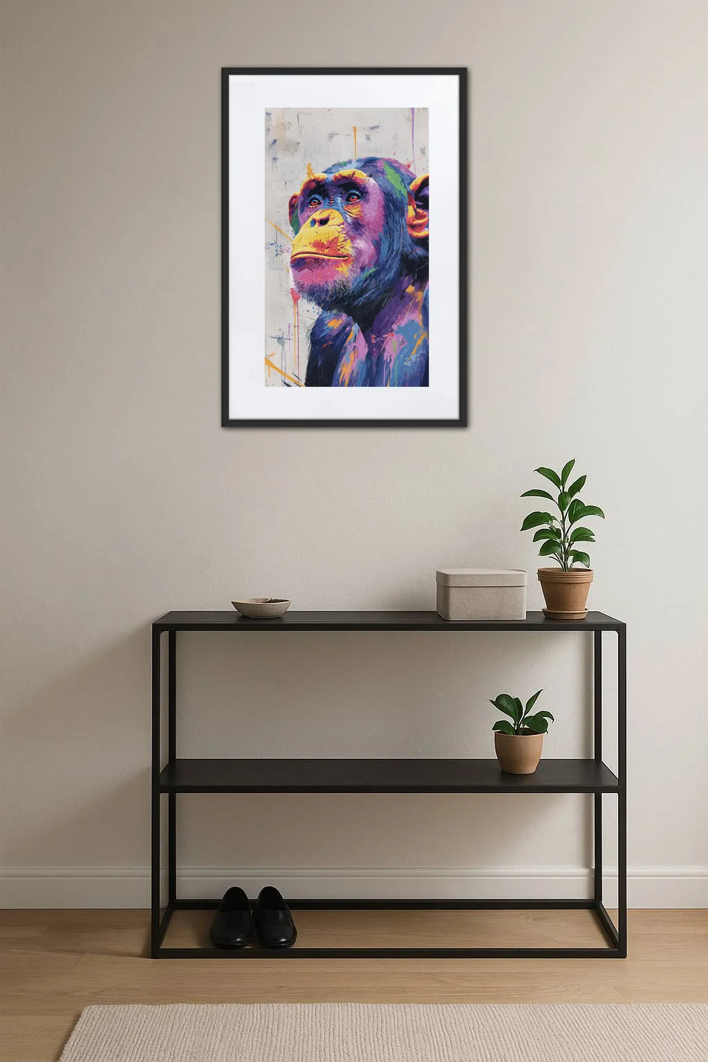 tableau singe pop art graffiti au dessus d’une console noire avec plantes
