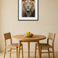 tableau tete de lion au mur dans une salle à manger avec table ronde en bois et chaises naturelles