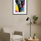 Tableau éléphant noir et blanc de face avec touches de couleurs vives au-dessus d’un fauteuil avec lampe et table basse