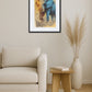 Toile éléphant pop art vintage accrochée au-dessus d’un fauteuil beige avec table en bois, livre et vase avec herbes séchées dans un intérieur clair